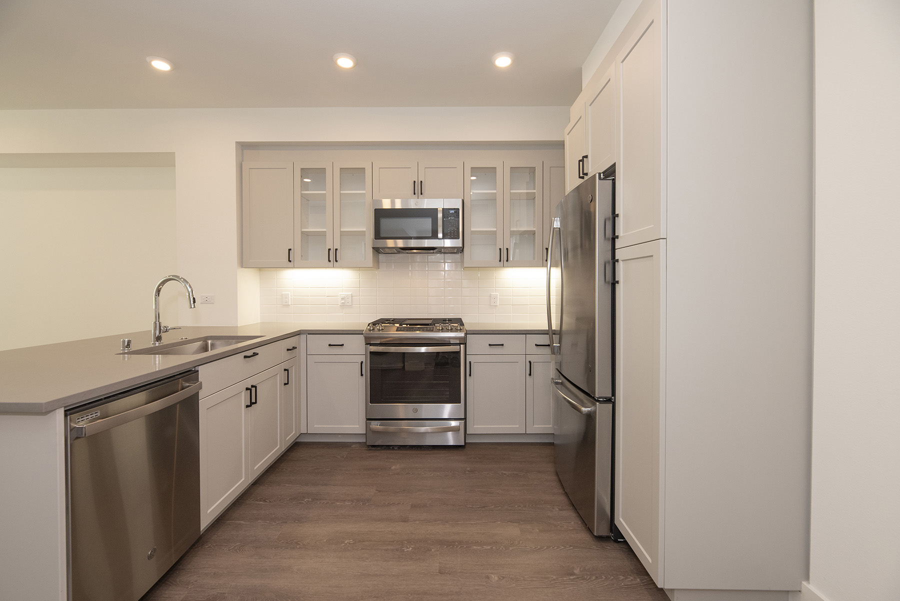 San Mateo CA Apartments - Azara - Updated Kitchen with White Cabinets, Stainless Steel Appliances, and Wood Flooring