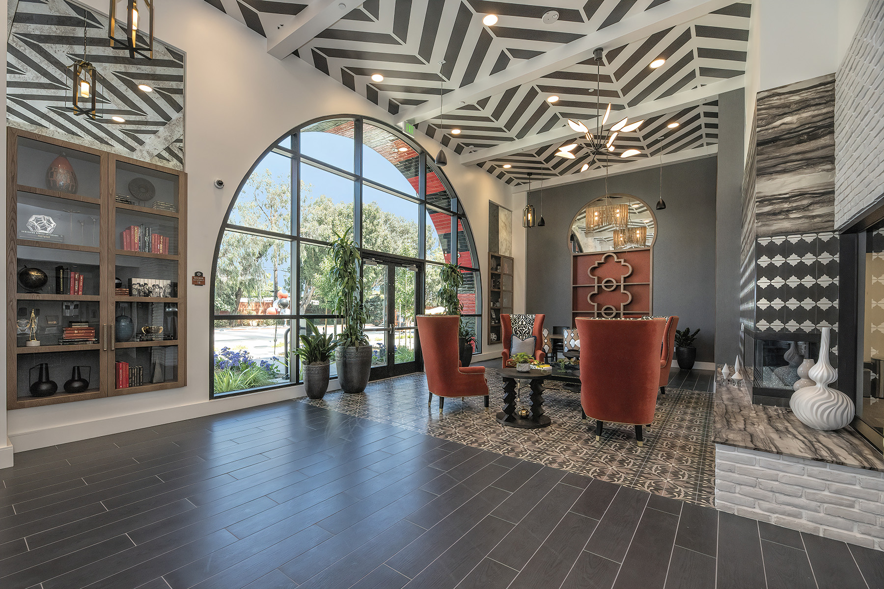 One-Bedroom Apartments in San Mateo, CA - Azara - Lobby with Vaulted Ceilings, Two-Toned Floors, Area Rug with Seating Area, and Built-In Cabinets.